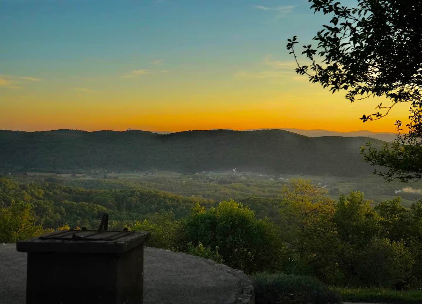 Zalazak sunca nad brežuljcima i šumama